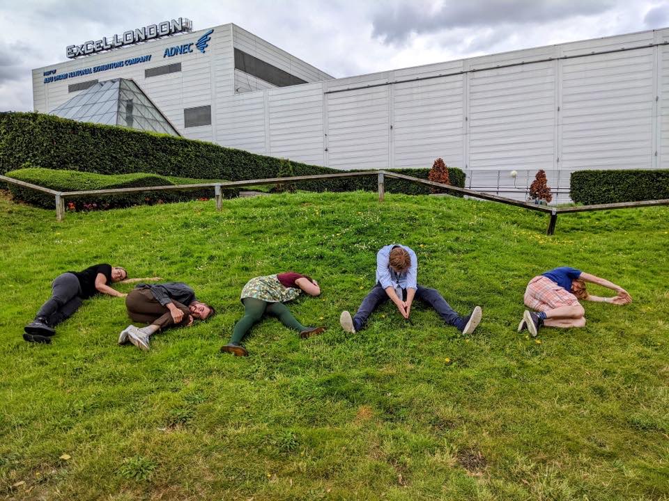 GOV.UK Forms team members lying on the grass, trying to spell out F-O-R-M-S with their bodies
